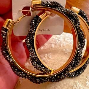 Large gold hoops with black stones intwined around hoop. Med. weight